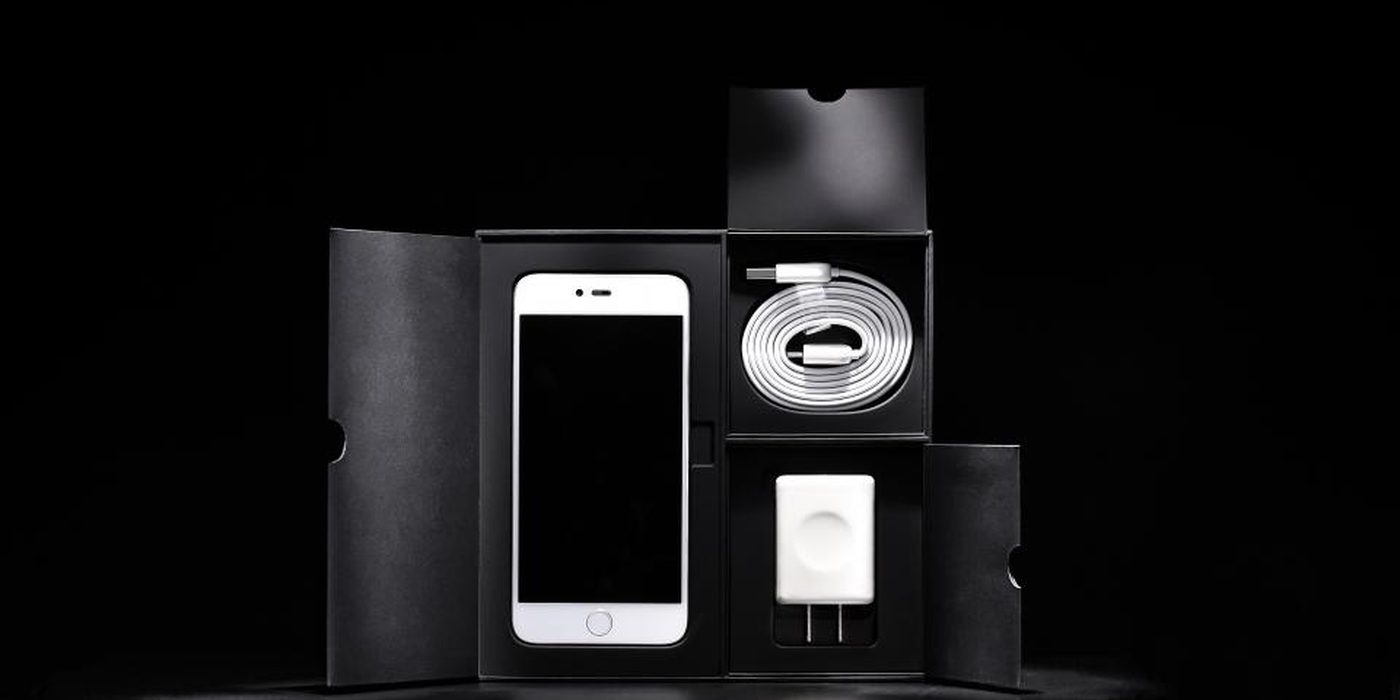 A phone and several matte black product boxes stacked against a dark background.