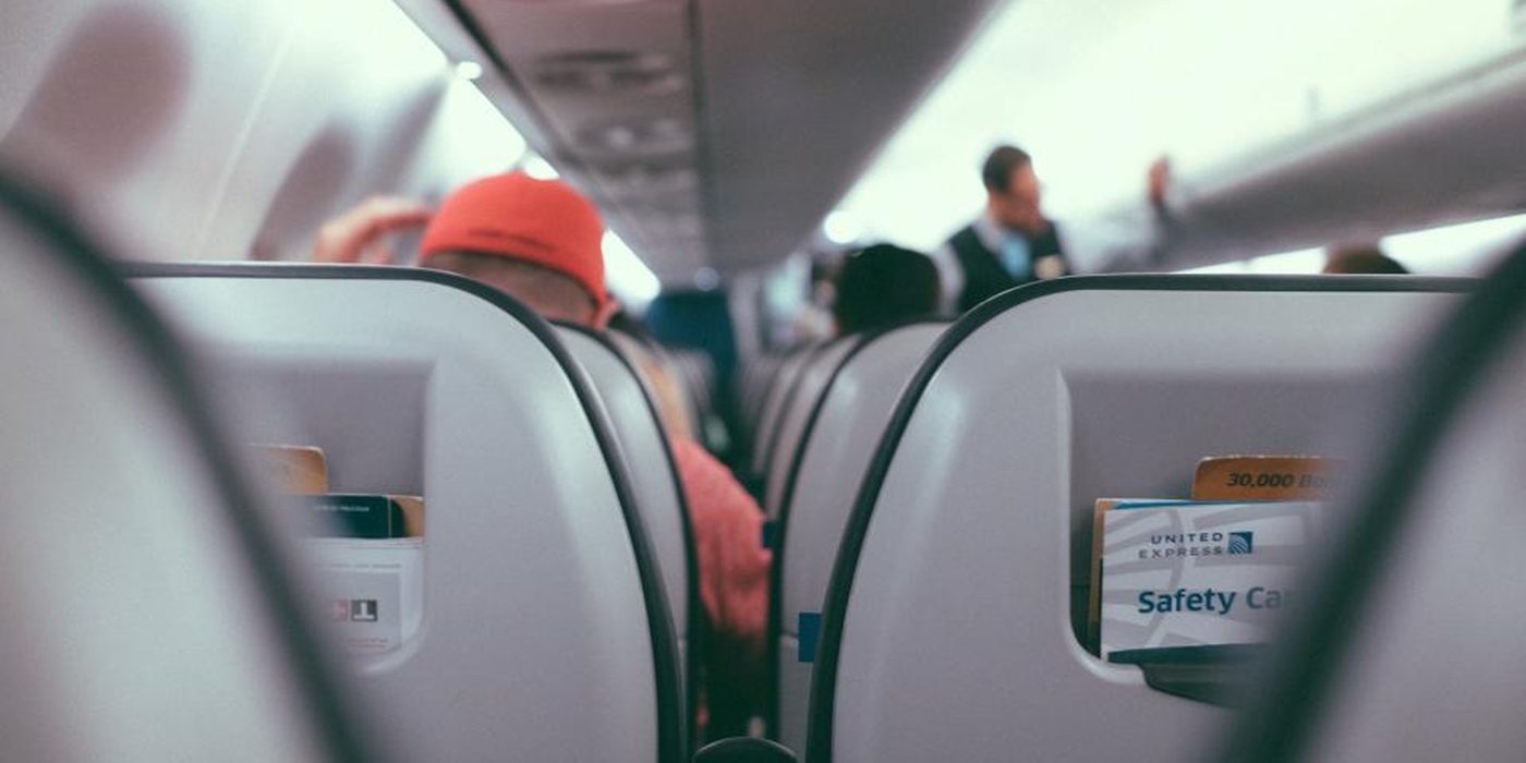 The view down an aircraft cabin from a passenger seat, headrests receding towards the front.