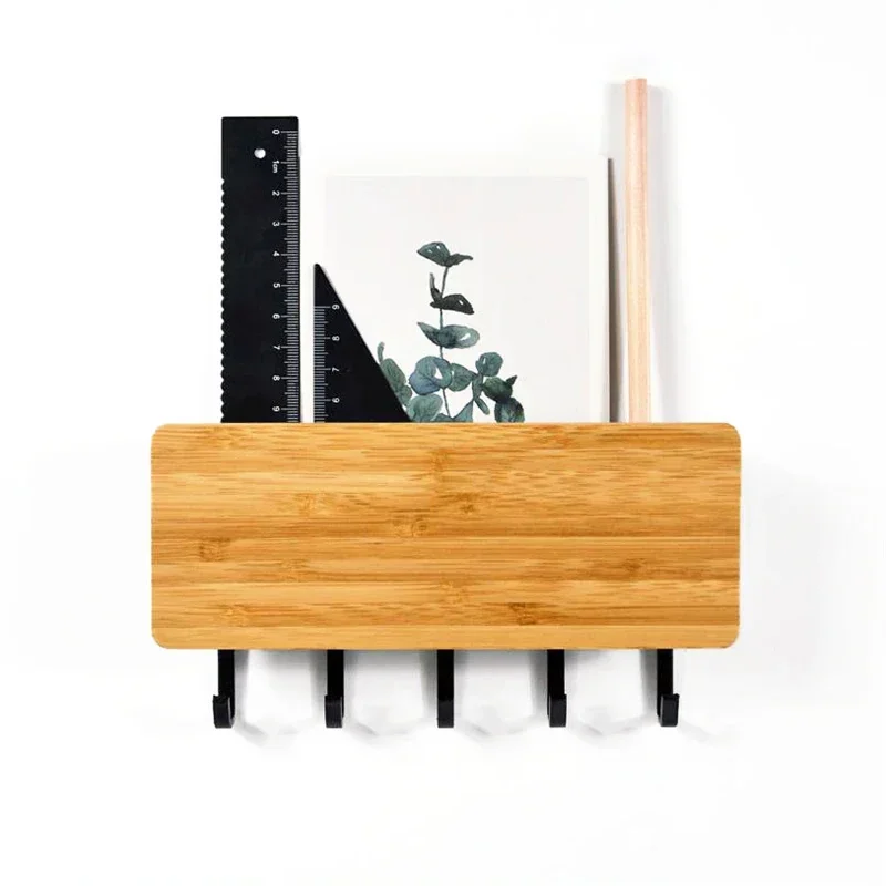 Bamboo board key rack seen head on, five black hooks below and a ruler, set square, print and wooden dowel in the tray