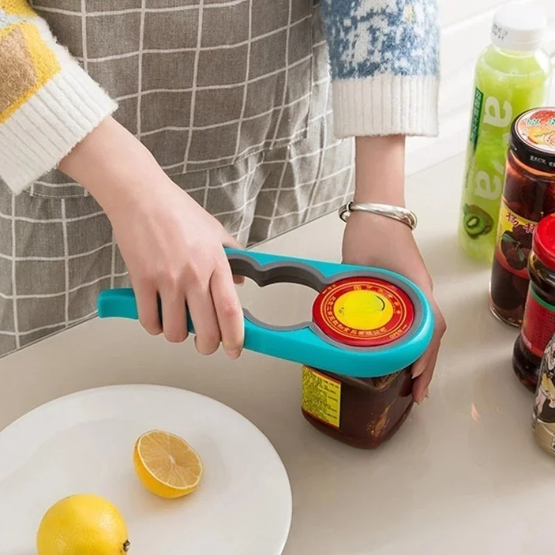Person using a blue and grey 4-in-1 jar opener to twist the lid off a jar of preserves