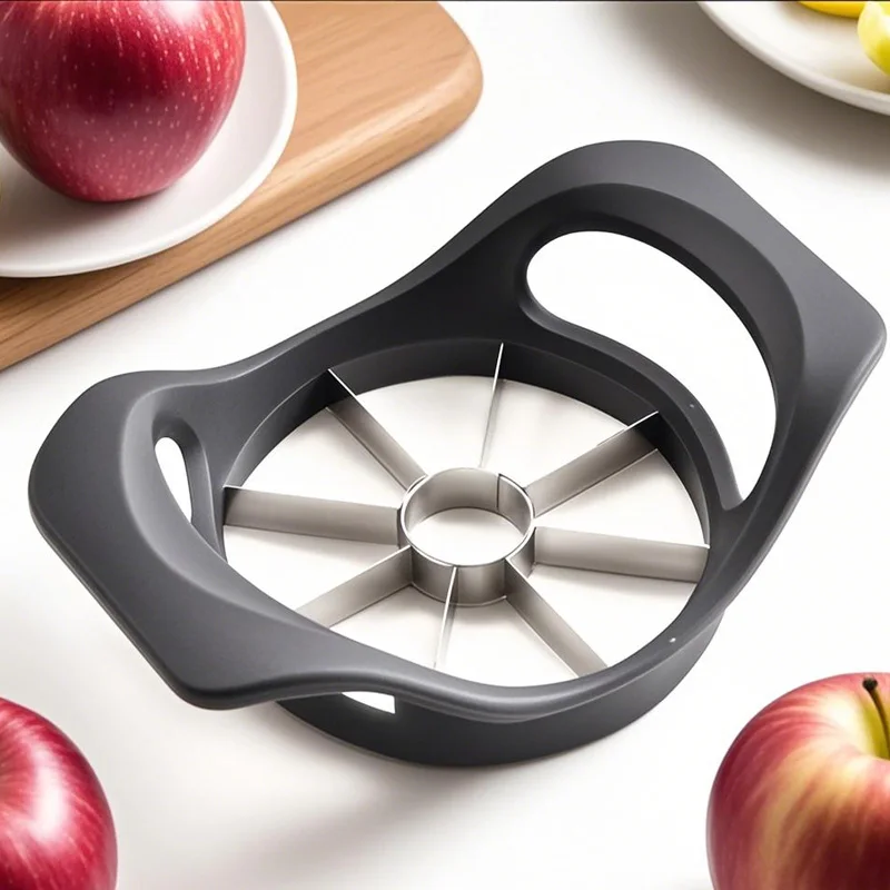 Close-up of the black apple slicer on a worktop beside whole red apples and a wooden chopping board