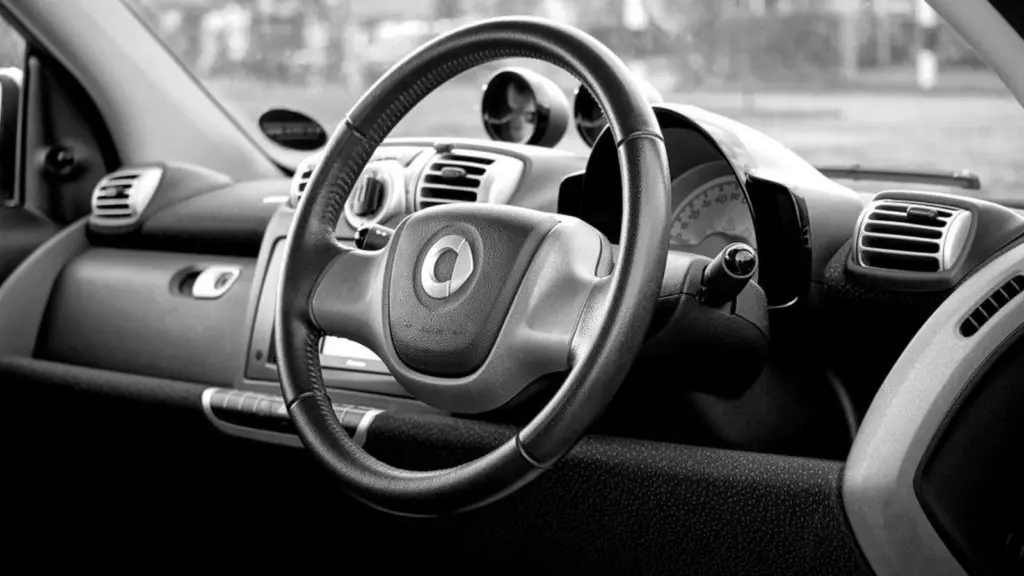 The driver's view of a car interior: steering wheel, dashboard vents and centre console.