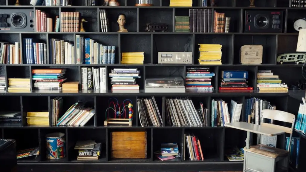 A wall of open shelving filled with books, records and storage boxes, each in its own compartment.